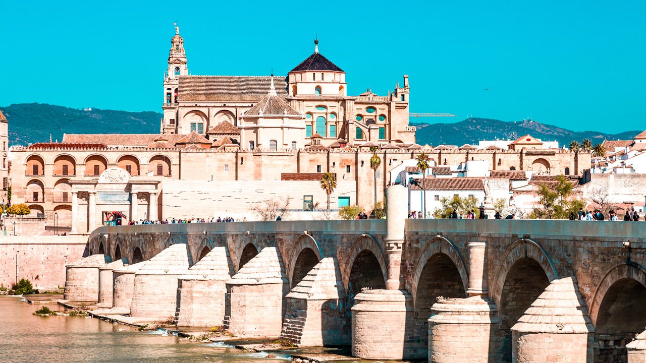 UnViaggioPerDue: La grande Mezquita di Cordoba e il ponte romano, con turisti che camminano e cieli azzurri.